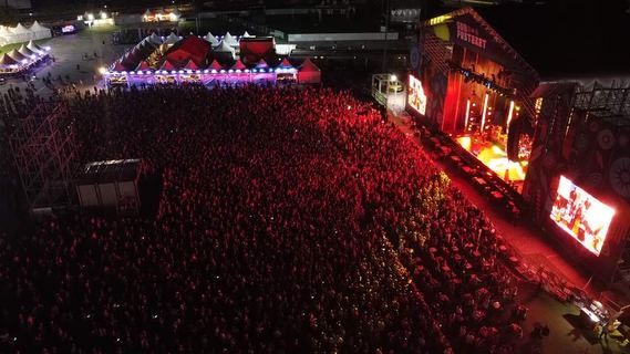 Un concierto en rojo con el recinto lleno, visto desde arriba